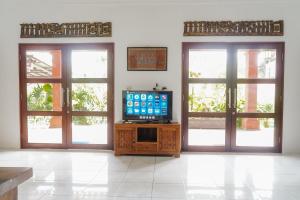 a living room with two doors and a television at Villa Bumi Ayu Sanur in Sanur