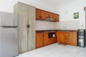 a kitchen with wooden cabinets and a stainless steel refrigerator at Villa Bumi Ayu Sanur in Sanur
