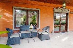 a patio with chairs and a table and windows at Villa Bumi Ayu Sanur in Sanur