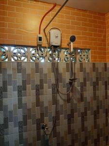 ein Bad mit einer Dusche und einem Mikrofon in der Unterkunft Homey Place with Garden view in Puerto Princesa