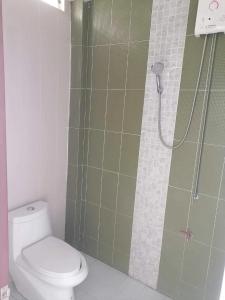 y baño con ducha y aseo. en Staychill Resort en Uttaradit