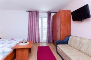 un soggiorno con divano e TV di Rooms Mladen P a Banjol