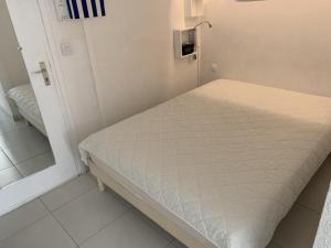 a small hospital room with a bed and a mirror at T1 Classé 3 Étoiles avec Animaux Admis et Climatisation - FR-1-571-49 in Balaruc-les-Bains