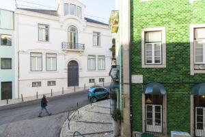 una persona caminando por una calle junto a los edificios en ALTIDO Cosy in Principe Real, en Lisboa