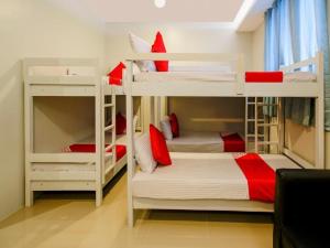 een slaapkamer met 2 stapelbedden met rode accenten bij Carcar Eco Farm Resorts in Carcar
