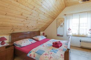 ein Schlafzimmer mit einem Bett in einem Holzzimmer in der Unterkunft Rustic Cottage With Heated Pool - Happy Rentals in Velika Buna