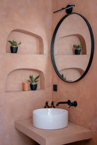 a bathroom with a sink and a mirror and potted plants at Black Honey in Ahangama