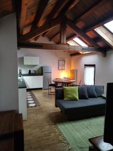een woonkamer met een bank en een keuken bij IL VICOLO_Carinissimo appartamento in centro storico, zona giorno mansardata in Belluno