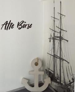 een model van een schip dat op een muur is geplakt bij Apartmenthaus Alte Börse in Carolinensiel