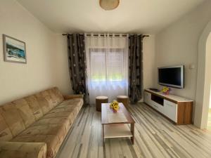 a living room with a couch and a tv at Apartment Vito in Povile +5 photos