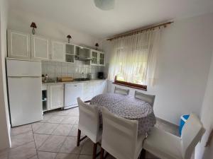 a kitchen with a table and chairs and a refrigerator at Apartment Vito in Povile
