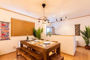 uma sala de jantar com uma mesa de madeira e cadeiras em Y's沖縄リゾートベースNo.1 em Onna