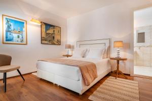 - une chambre blanche avec un lit et une chaise dans l'établissement Villa Vita, à Trogir