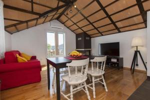 a living room with a table and chairs and a red couch at Villa Burica in Vinišće