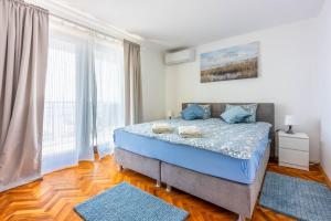 a bedroom with a bed with blue pillows at Villa Turquoise breeze in Klenovica +35 photos