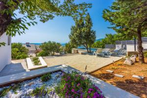 a patio with chairs and flowers in a yard at Villa Turquoise breeze in Klenovica