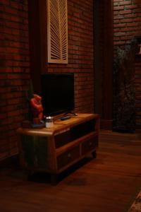 TV sobre una mesa de madera en Pondok Sugara, en Tampaksiring
