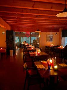 ヴィチェンツァにあるAlbergo Torreの木製のテーブルと椅子、キャンドルが備わるレストラン