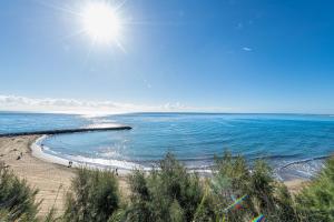 a view of a beach with the sun in the sky at APARTAMENTO a PIE del MAR in Playa del Ingles +15 photos