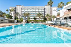 a large swimming pool with a hotel in the background at APARTAMENTO a PIE del MAR in Playa del Ingles