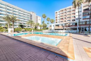 a swimming pool in front of a large apartment building at APARTAMENTO a PIE del MAR in Playa del Ingles