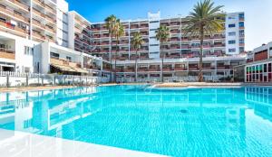 a large swimming pool in front of a building at APARTAMENTO a PIE del MAR in Playa del Ingles