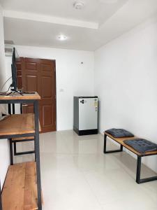 a room with a computer and a desk and a refrigerator at Dm-udon (ดีเอ็ม อุดรธานี) in Udon Thani