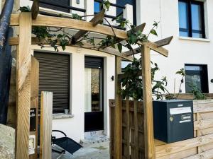 a wooden pergola in front of a house at Apt RDC avec sa terrasse privée in Saint Malo