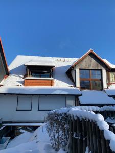 uma casa com neve no telhado em Ferienwohnung Kleine Auszeit in Altenau em Altenau
