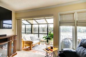 ein Wohnzimmer mit großen Fenstern und einem Sofa in der Unterkunft Waterfront Vacation Rental on Savannah River! in Augusta