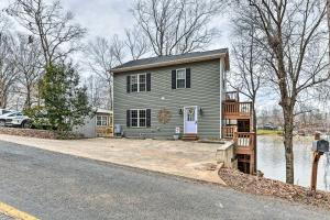 ein graues Haus mit einem davor geparkt in der Unterkunft Lakefront Lexington House with Spacious Deck! in Lexington