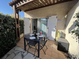 czarny stół i krzesła na patio w obiekcie Pavillon T3 avec Mezzanine, Parking, Piscine, Clim, proche plage et commerces, animaux acceptés - FR-1-702-31 w Cap d'Agde