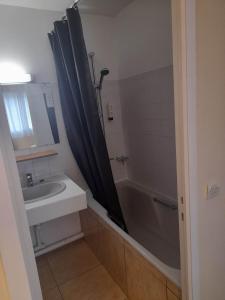 ein Bad mit einer Badewanne, einem Waschbecken und einer Dusche in der Unterkunft Hotel bar Saint Christophe in Le Tilleul