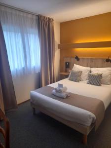 um quarto de hotel com uma cama grande com toalhas em Hotel bar Saint Christophe em Le Tilleul