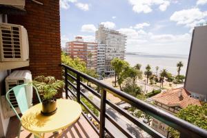 uma varanda com uma mesa e vista para o oceano em Selina Montevideo em Montevidéu