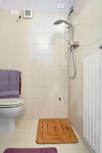 un baño con ducha y una alfombra de madera en el suelo. en Your little Loft, en Villafranca di Verona