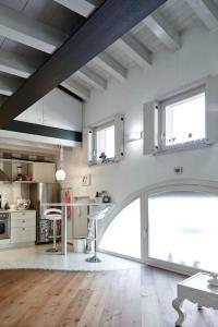 una gran cocina blanca con mesa y algunas ventanas en Your little Loft, en Villafranca di Verona