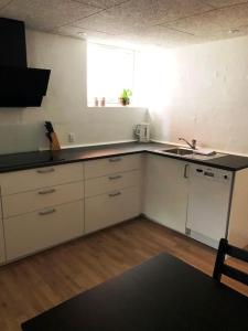 a kitchen with white cabinets and a sink and a window at Lejlighed i midtby - tæt på alt in Viborg