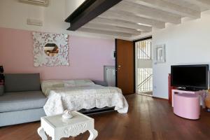 um quarto com uma cama, um sofá e uma televisão em Your little Loft em Villafranca di Verona