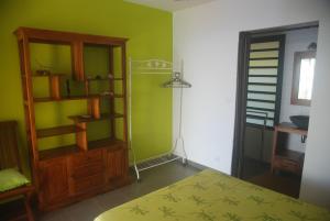 um quarto com uma cama e uma parede verde em La case Tori em Saint-Leu