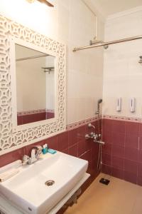 a bathroom with a sink and a mirror at CherryStay Holiday Resort -Candolim Beach in Candolim
