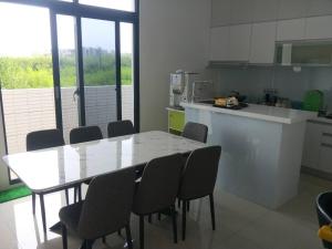 a kitchen with a table and chairs in a room at 晨光夜色 in Magong