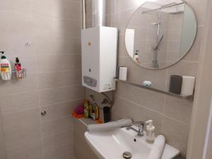 La salle de bains est pourvue d'un lavabo et d'un miroir. dans l'établissement Budaiapertment, à Budapest