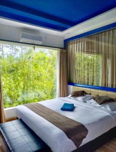 a bedroom with a large bed with a large window at Bombora Surf Camp in Uluwatu