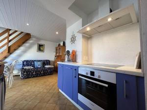 eine Küche mit blauen Schränken und ein Wohnzimmer in der Unterkunft Maison Saint-Denis-d'Oléron, 4 pièces, 6 personnes - FR-1-246A-196 in Saint-Denis-dʼOléron