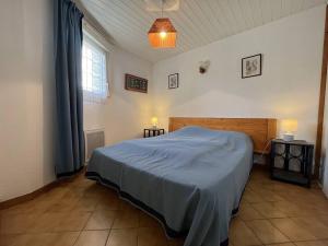 ein Schlafzimmer mit einem Bett mit einer blauen Decke darauf in der Unterkunft Maison Saint-Denis-d'Oléron, 4 pièces, 6 personnes - FR-1-246A-196 in Saint-Denis-dʼOléron