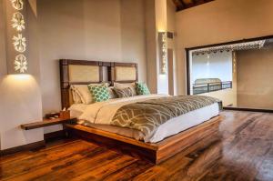 a bedroom with a large bed with a wooden floor at Wattura Resort & Spa in Negombo