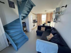 eine blaue Treppe in einem Wohnzimmer mit Sofa in der Unterkunft Appartement Wimereux, 2 pièces, 4 personnes - FR-1-675-16 in Wimereux