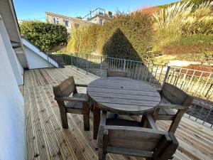 a wooden table and two chairs on a deck at Southover Beach in Woolacombe