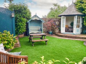 a garden with a picnic table and a gazebo at Lilac Barn in Newton Reigny